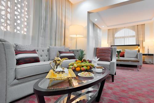 a living room with a couch and a table with fruit on it at Al Joud Boutique Hotel, Makkah in Makkah