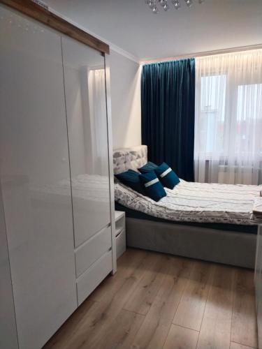 a bedroom with a bed with blue pillows at Apartament w centrum in Kętrzyn