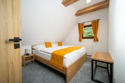 1 dormitorio con cama y ventana en Rezort pri jazere Podbanské, en Pribylina
