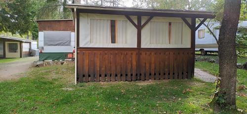 a house with a gate and a tree in a yard at Camping Chon du Tarn in Bédouès