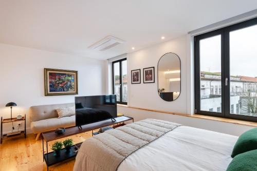 a bedroom with a bed and a couch and a mirror at Fontainhas Royal in Porto