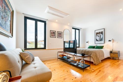 a living room with a couch and a tv at Fontainhas Royal in Porto