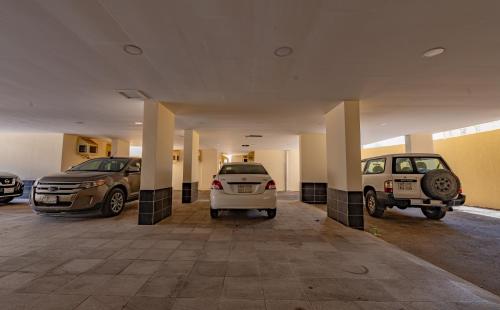 eine Gruppe von Autos, die auf einem Parkplatz geparkt sind in der Unterkunft الياسمين in Dschidda