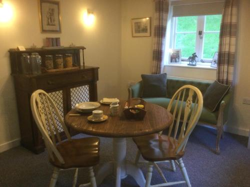 a dining room with a table and chairs and a couch at The Cottage in Wadhurst