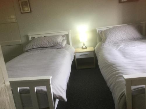 dos camas sentadas una al lado de la otra en un dormitorio en The Cottage, en Wadhurst
