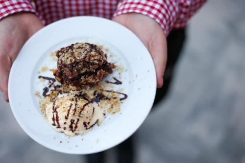 a person holding a white plate with a dessert at Rezort pri jazere Podbanské in Pribylina