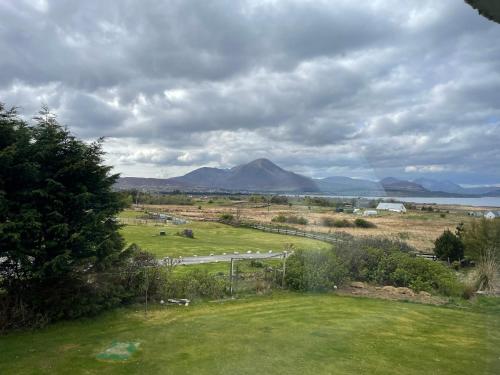 a view of a field with a mountain in the distance at Ruisgarry Accommodation in Breakish