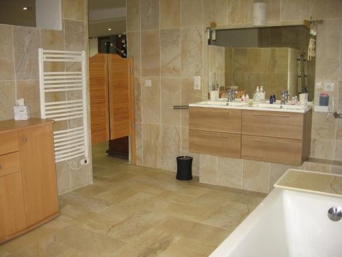 La salle de bains est pourvue d'une baignoire et de 2 lavabos. dans l'établissement Les Genêts, à Fayence