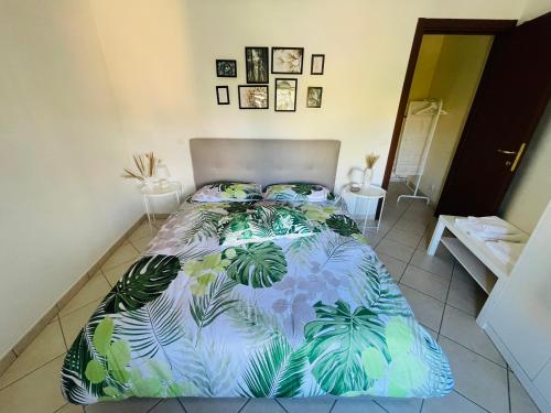 a bedroom with a bed with a blue and green comforter at Castelli Home - Castelli Apartments in Albano Laziale