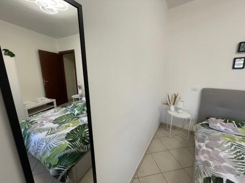 a mirror in a room with two beds and a table at Castelli Home - Castelli Apartments in Albano Laziale