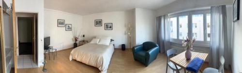 a hotel room with a bed and a blue chair at Schweiz (301) in Basel