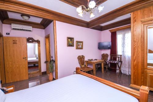 a bedroom with a bed and a table and chairs at Brilant Antik Center in Tirana