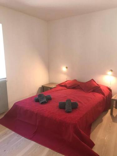 - une chambre avec un lit rouge et 2 serviettes noires dans l'établissement Spectacular renovated watermill, à Albières