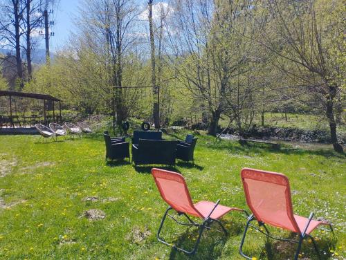a group of chairs sitting in the grass at Complex Adela Transfăgărășan in Cîrţişoara