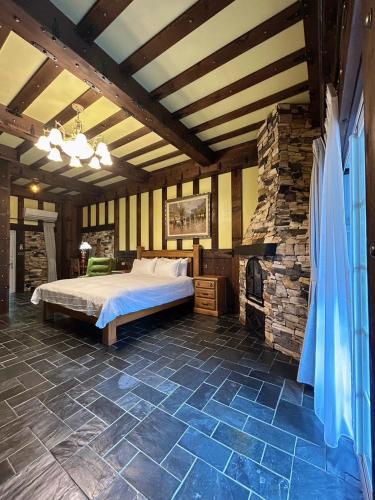 a bedroom with a bed and a stone fireplace at 日月潭森堡萊夫莊園 in Yuchi