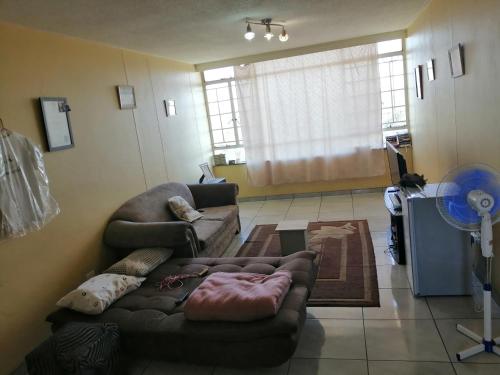 a living room with a couch and a table at Kingswood Flats in Pretoria