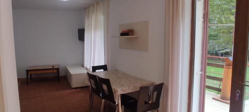 a dining room with a table and chairs and a window at Complex Adela Transfăgărășan in Cîrţişoara