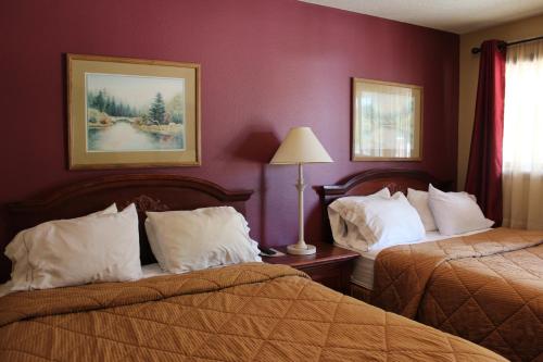 una habitación de hotel con 2 camas y una lámpara en Gold Country Inn, en Deadwood