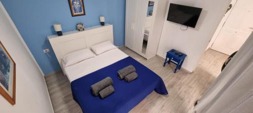 sypialnia z niebiesko-białym łóżkiem i telewizorem w obiekcie 2 Camere Splendida casa vacanze in Tenerife del Sur Casa Trilly w Aronie
