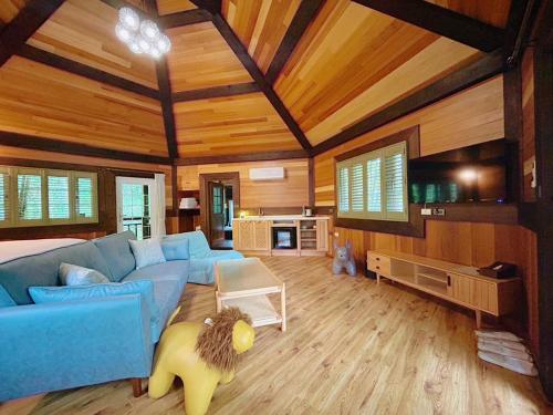 a living room with a blue couch and wooden ceilings at 日月潭森堡萊夫莊園 in Yuchi