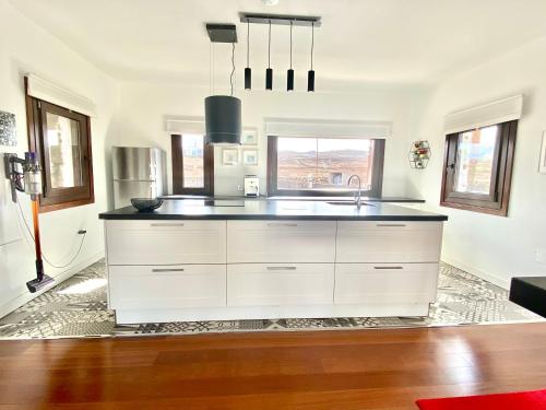 a kitchen with white cabinets and a sink at Casa Estela in Villaverde