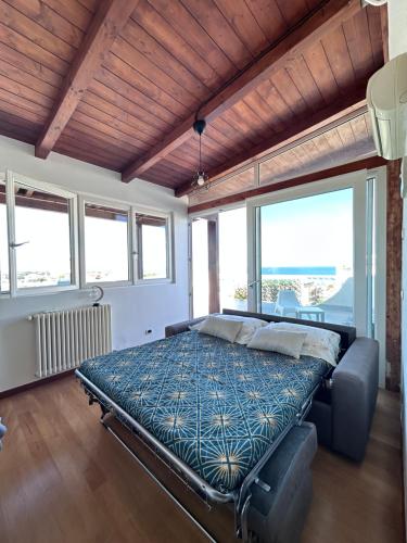 a bedroom with a bed in a room with windows at ISOLA ROVI in Santo Spirito