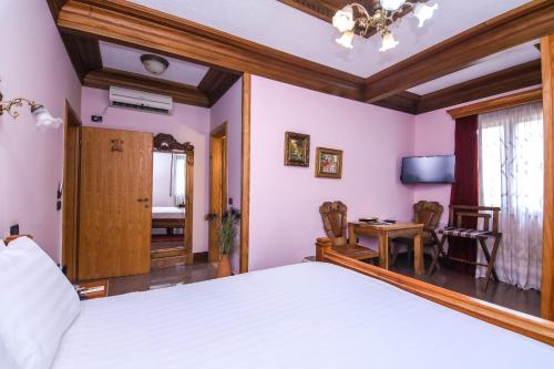 a bedroom with a large bed and a table at Brilant Antik Center in Tirana