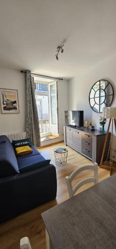 a living room with a blue couch and a table at Villa Duchatel Appt 2/4 pers in Le Mont-Dore