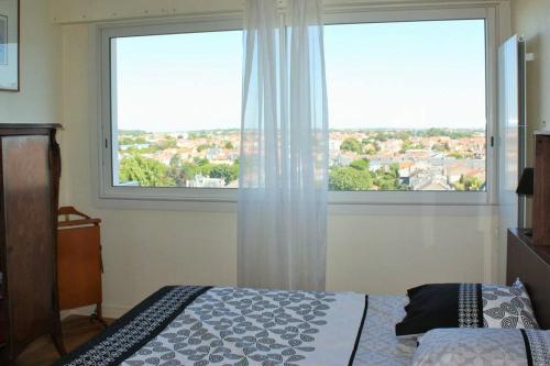 เตียงในห้องที่ Appartement lumineux avec vue panoramique sur La Rochelle