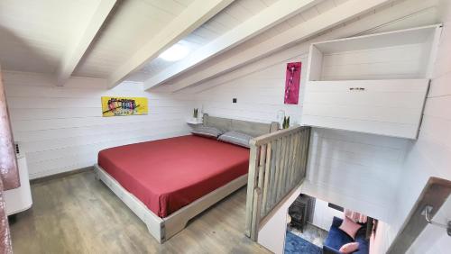 a small bedroom with a red bed in the attic at Casa de Madera in Pávliani