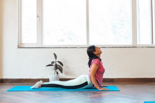 a woman sitting on a yoga mat in a room at Vyom Boutique Hotel Rishikesh in Rishīkesh
