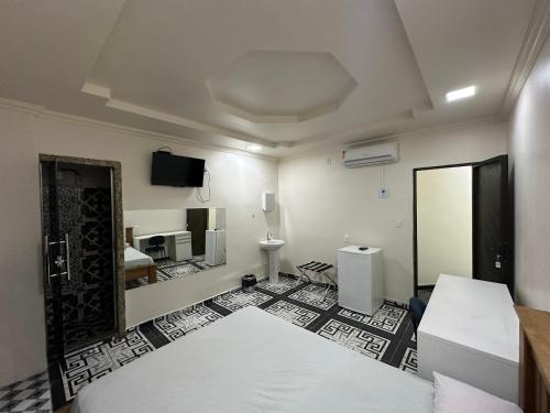 Habitación con cama y TV en la pared. en 3D Hotel, en Manaus
