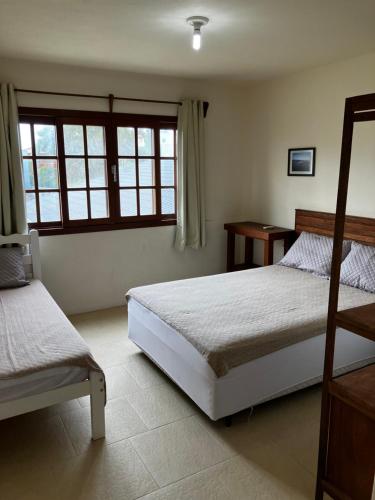 A bed or beds in a room at Townhouse composta por 4 triplex duas suítes a duas quadras do mar