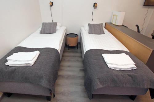 two beds in a room with towels on them at Kuukkeli Apartments Inari in Inari