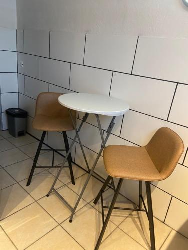 a white table and two chairs in a room at Happyhome in Saint-Pierre