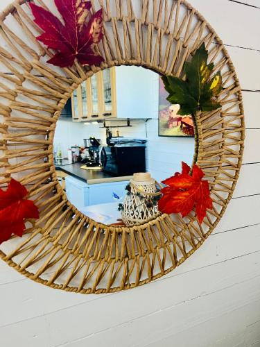 a mirror on the wall of a kitchen with autumn leaves at 15 min från Ullared! Ny stuga med hög standard! in Älvsered
