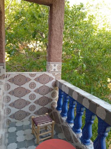 a porch with a table and a chair on it at Gite akswal amssakrou in Ikis