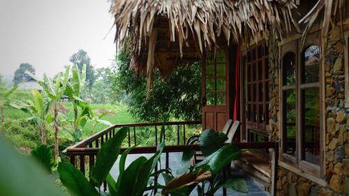 a porch of a house with a thatch roof at Lua Pu Luong in Pu Luong