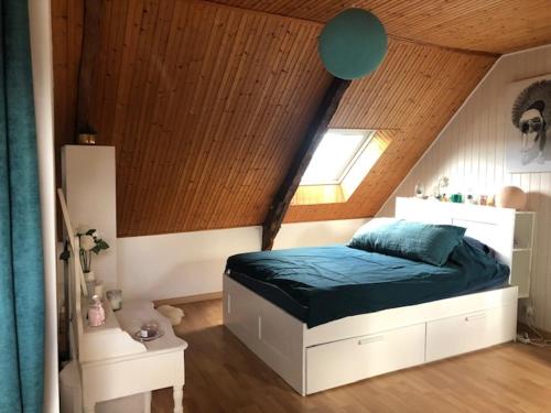 een slaapkamer met een bed en een houten plafond bij APPEL A LA BEAUTE in La Vicomté-sur-Rance
