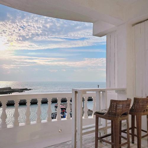 a balcony with chairs and a view of the ocean at White&Light B&B in Manzhou
