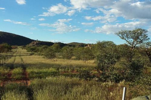 a field of grass with trees and a mountain at Orpheus Inn in Kaneb Pos