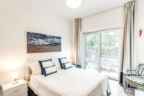 a white bedroom with a bed and a window at Il Canto delle Sirene in Sorrento