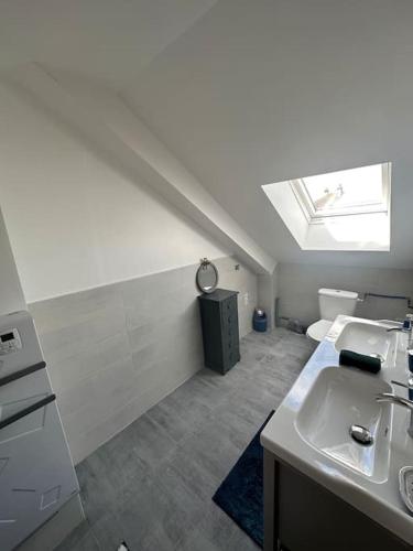 La salle de bains blanche est pourvue d'un lavabo et d'une lucarne. dans l'établissement Jolie maison style champenois Classement 3 étoiles Gîtes de France, à Barberey-Saint-Sulpice