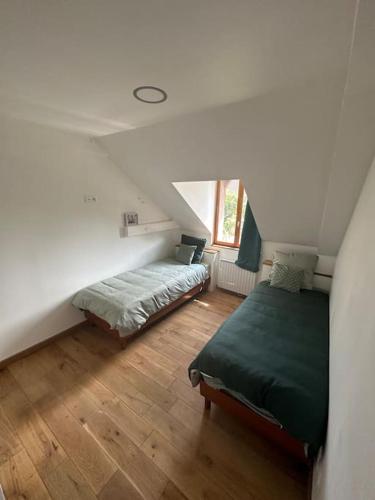 - une chambre mansardée avec 2 lits et une fenêtre dans l'établissement Jolie maison style champenois Classement 3 étoiles Gîtes de France, à Barberey-Saint-Sulpice