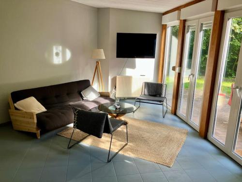 uma sala de estar com um sofá e uma televisão em Haus am Lübbesee em Templin