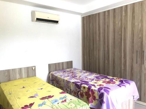 um quarto com 2 camas e uma colcha com flores em Casa térrea em Guarajuba para Veraneio em Camassari