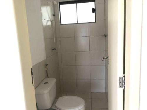 een kleine badkamer met een toilet en een raam bij Casa térrea em Guarajuba para Veraneio in Camassari