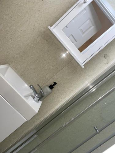 um balcão de casa de banho com um lavatório e um espelho em Cosy Hideaway Close to Town em Reading