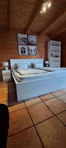una camera da letto con un grande letto in una camera in legno di Studio im Blockhaus am Chiemsee a Bernau am Chiemsee
