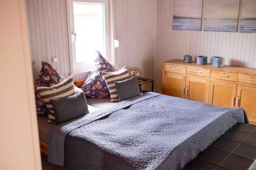 a bedroom with a bed with pillows and a window at Suedseeurlaub2 - Ferienhaus in Otterndorf in Otterndorf